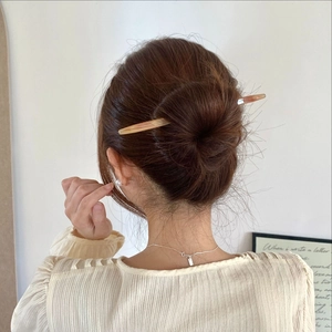 Gros plan d'un pic à cheveux ambre minimaliste pour fixer un chignon élégant