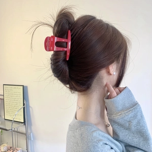 Pince à cheveux mate rouge foncé élégante portée dans un chignon sur cheveux bruns