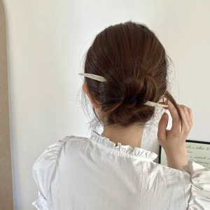 Épingle à cheveux minimaliste en acétate blanc crème élégamment portée en chignon