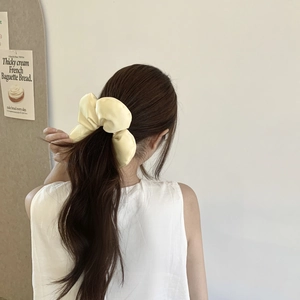 Détail d'un chouchou en satin jaune clair porté dans les cheveux style rétro français