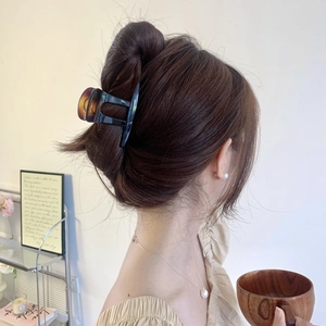 Détail d'une grande pince à cheveux en motif écaille de tortue sur un chignon chic