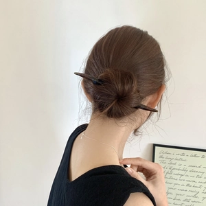 Détail d'un pic à cheveux à motif écaille de tortue coiffé dans un chignon élégant