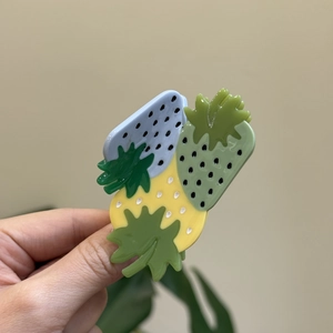 Détail de la pince à cheveux fraise mignonne en acétate avec design à trois fraises