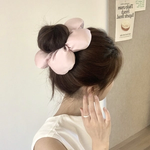 Chouchou floral en soie rose porté en queue de cheval avec un style vintage chic