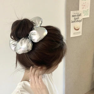 Chouchou argenté métallisé pour femme présenté dans une photo de coiffure lifestyle de qualité