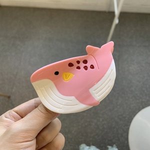 Détail d'une pince à cheveux en forme de baleine rose en acétate avec finition brillante