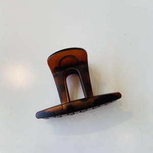 Détail d'une pince à cheveux motif écaille de tortue avec arche ambre et dents de peigne