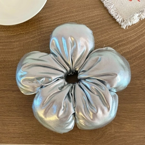 Gros plan d'un chouchou floral argenté métallique avec finition brillante sur bois
