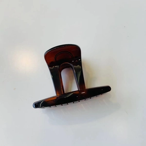 Détail macro d'une pince à cheveux en ambre avec un design à poignée géométrique creuse