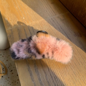 Gros plan sur une pince à cheveux en fausse fourrure rose et orange tachetée