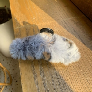 Détail d'une pince à cheveux en peluche imitation lapin avec ressort noir robuste