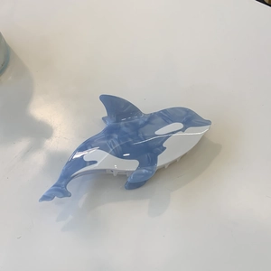 Pince à cheveux baleine orque en acétate avec motif marbré bleu sur fond blanc