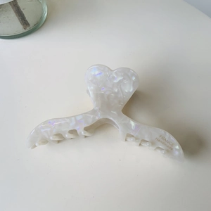 Pince à cheveux cœur blanc irisé avec texte France Handmade sur fond crème élégant