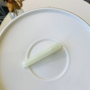 Macro view of light green resin barrette clip featuring gold Barrette la France script