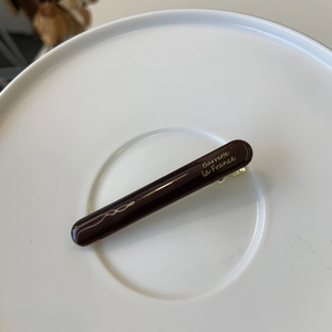 Detailed close-up of dark brown glossy resin duckbill clip with gold Barrette la France text