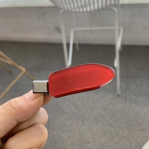 Gros plan détaillé d'une pince à cheveux en acétate bordeaux avec surface polie et base en métal
