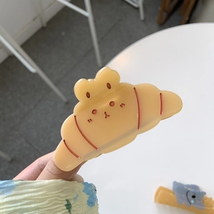 Cute croissant-shaped shark hair claw clip with adorable cartoon animal facial expression