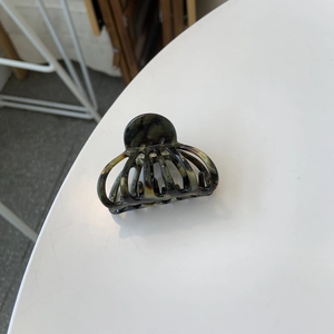 Detail view of tortoiseshell acetate claw clip showing internal metal spring and teeth