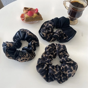 Tres coleteros de leopardo en telas mixtas presentados con café para un estilo elegante