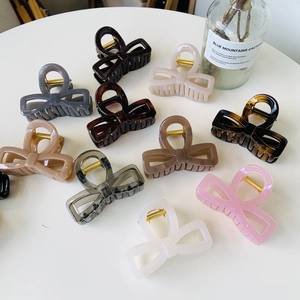 Variety of colors showing butterfly hair claw clips arranged on a stylish white table
