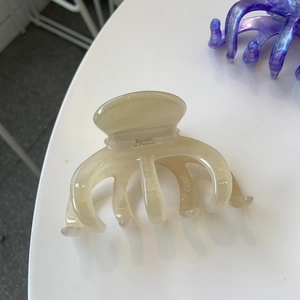 Détail de la pince à cheveux en acrylique crème avec inscription Barrette La France dorée