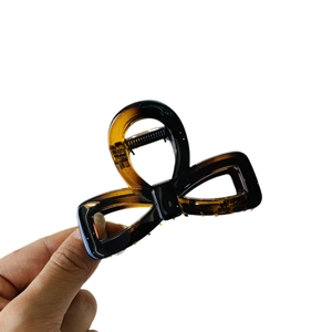 Handheld tortoiseshell acetate bow hair claw clip with vintage amber pattern design