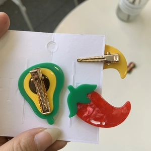 Detailed back view of resin fruit hair clips with secure golden metal duckbill clamps