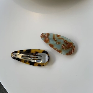 Détail de barrettes à cheveux en acétate fait main avec motif écaille et dos en métal