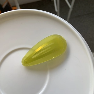 Détail de la pince à cheveux jaune en acétate avec texte France et fini brillant