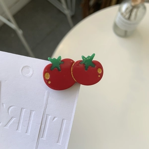 Close-up of cute tomato shaped acetate hair clips with red body and green leaves
