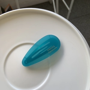Vue macro d'une barrette goutte en acétate bleu ciel avec détails dorés élégants