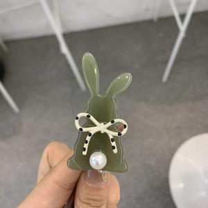 Dettaglio molletta per capelli a forma di coniglio verde oliva con fiocco e perla