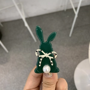 Dettaglio molletta a forma di coniglio verde scuro con fiocco e perla bianca