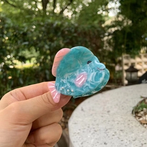 Détail d'une pince à cheveux en acétate rose et bleu sarcelle avec texture marbrée