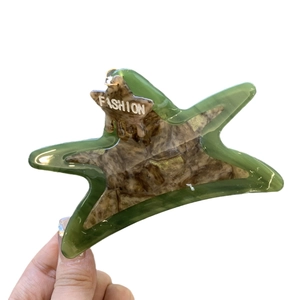Star-shaped acetate claw clip with translucent green marble pattern and star pendant
