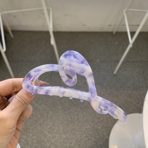 Detail of purple marble acetate hair claw clip featuring a hollow heart-shaped design