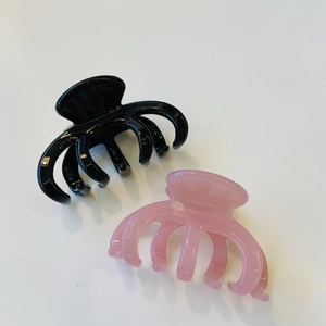 Detail of large black and pink octopus hair claws with interlocking teeth and glossy finish