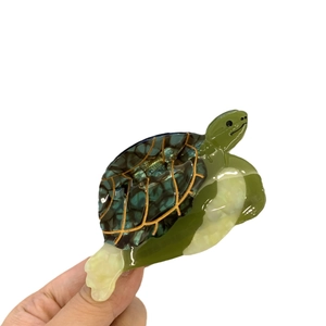 Handheld turtle hair claw clip made of tortoiseshell acetate with ocean design and golden shell lines