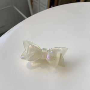 Elegant white acetate bow hair clip with glossy pearlescent finish and handmade engraving