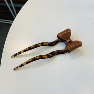 Gros plan sur un pic à cheveux en écaille ondulée avec un nœud marron brillant