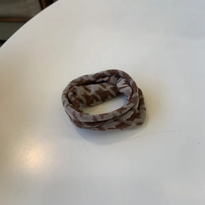 Detailed view of brown houndstooth knitted scrunchie with soft fabric texture