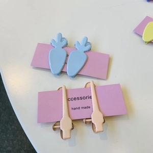 Macro view of pastel pink and light blue bow clips set on a purple display card