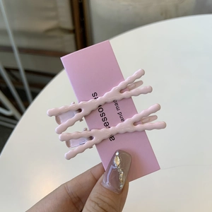 Fermagli per capelli rosa a forma di X con finitura lucida su cartoncino display