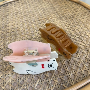 Détail de jolies pinces à cheveux en acétate en forme d'ours rose et marron avec nœuds