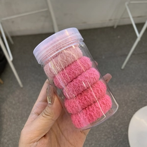 Lot d'élastiques à cheveux roses dans un pot de rangement pour coiffure féminine