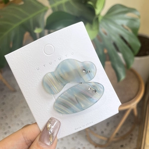Two-piece set of light blue marble hair clips with rhinestones on a display card