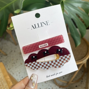 Cute red bear hair clip set with checkered patterns and bows on a card display
