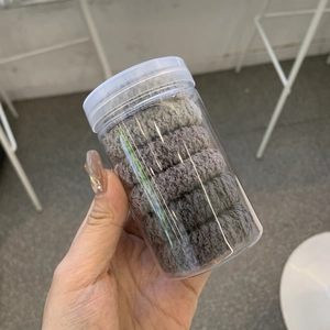 Ensemble d'élastiques à cheveux en peluche grise dans un contenant cylindrique en plastique