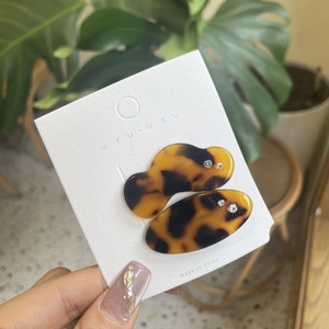 Detail of leopard print resin hair clips with rhinestones on a display card