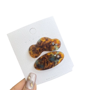 Set of two tortoiseshell hair clips with crystal accents on a white display card